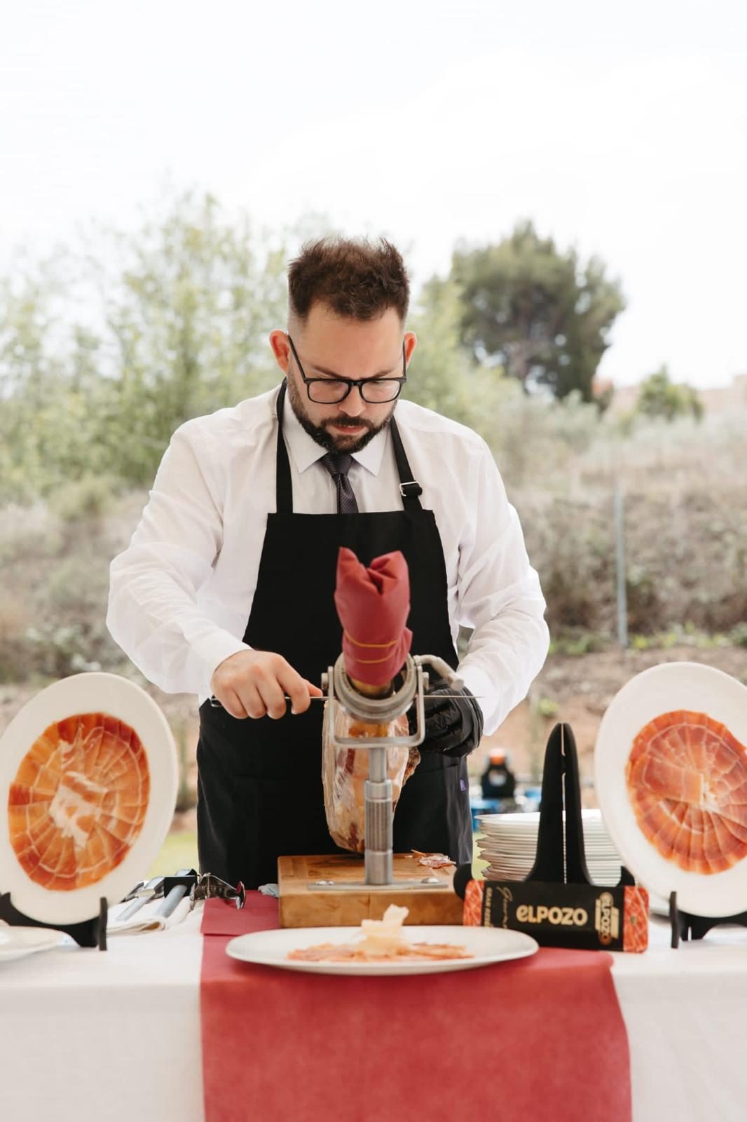 Adrián, cortador profesional, cortando un jamón ibérico en un evento al aire libre en Murcia