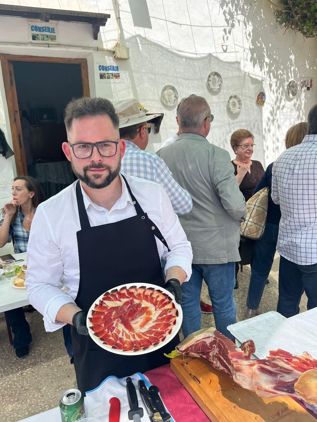 Adrián, cortador de jamón profesional, presentando un plato en un evento popular en Murcia